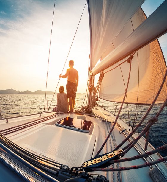 Couple,Enjoying,Sunset,From,The,Deck,Of,The,Sailing,Boat